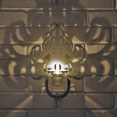 Stilfull lampett för värmeljus som ger en effektfull skugga på väggen